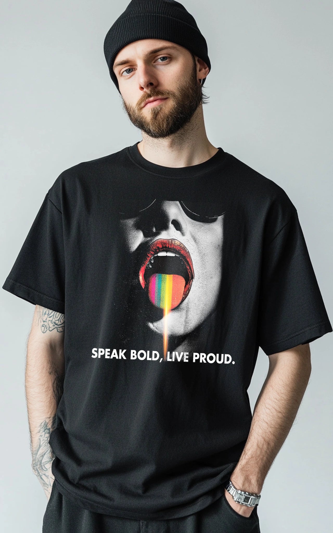 Model in einem lässigen Oversize-T-Shirt mit dem Schriftzug "Speak Bold, Live Proud" und einem großen, bunten Zungen-Print.